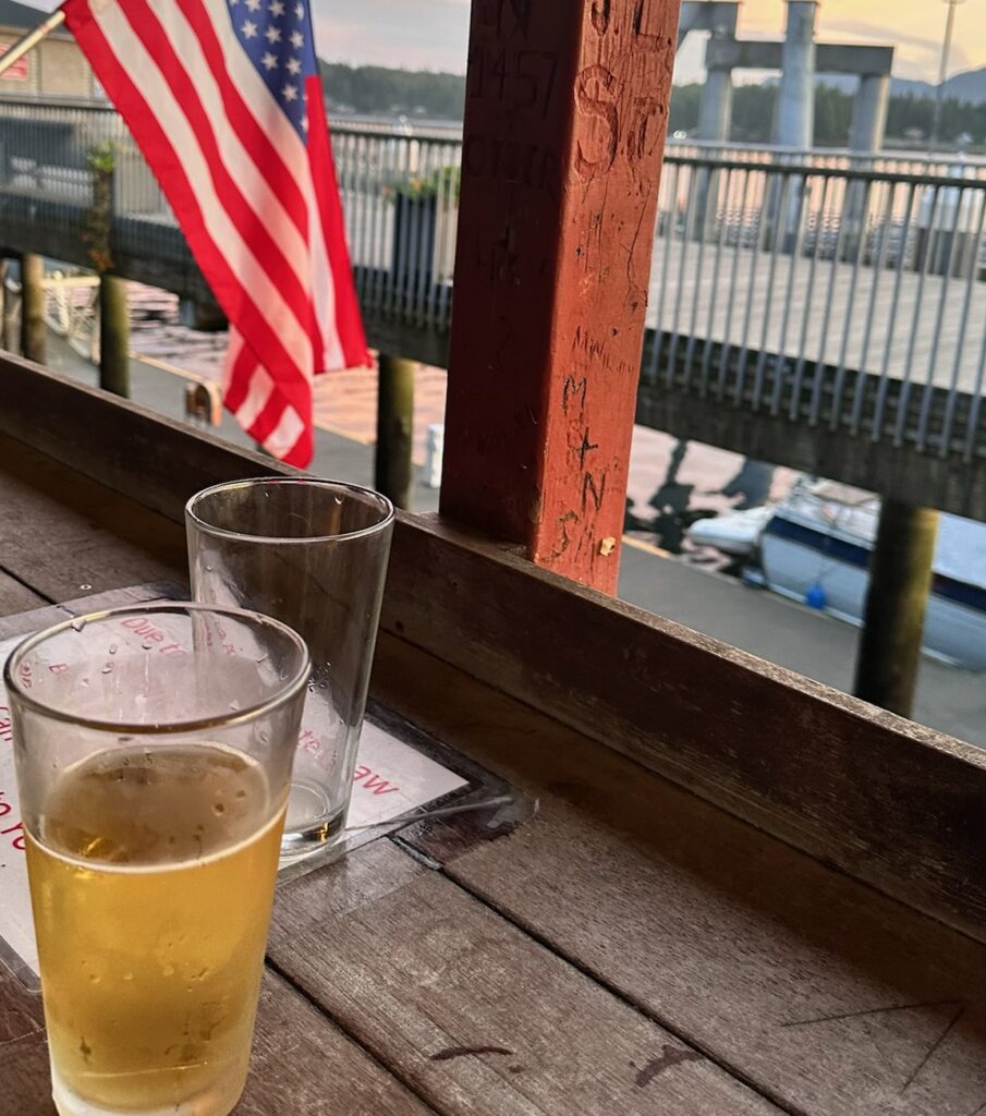 A guest enjoying a cold beer while the sun is setting after a ketchikan fishing charter