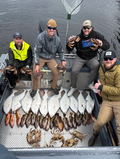 Captain Tony of Ketchikan Finest Fishing Charters, sitting on a boat with his guests surrounded by halibut, rockfish, crab and cod.